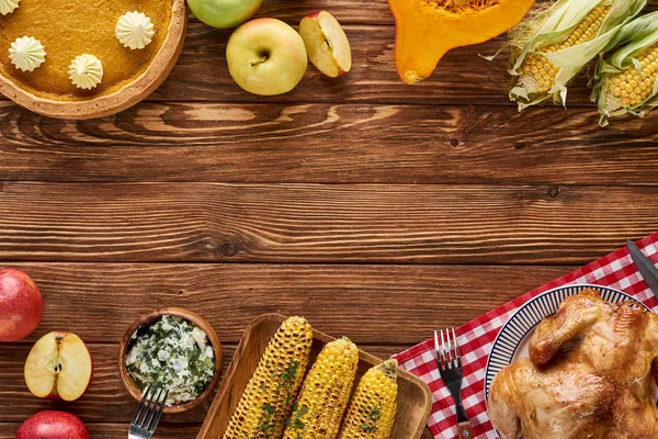 Blick von oben auf gebratenen Truthahn, Kürbiskuchen und gegrilltes Gemüse auf Holztisch — Stockfoto