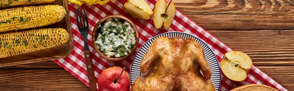 Top view of roasted turkey, grilled corn and apples served on wooden table with red napkin, panoramic shot — Stock Photo