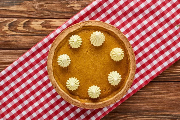 Top view of delicious pumpkin pie served on rustic plaid napkin on wooden table — Stock Photo