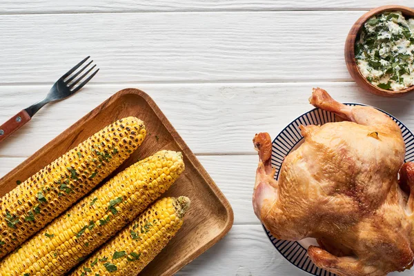 Top view of roasted turkey, apples and grilled corn served on white wooden table — Stock Photo