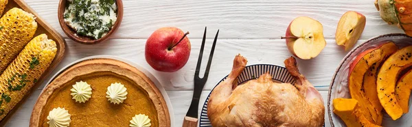 Vue de dessus de dinde rôtie, tarte à la citrouille et maïs grillé servi sur table en bois blanc, vue panoramique — Photo de stock