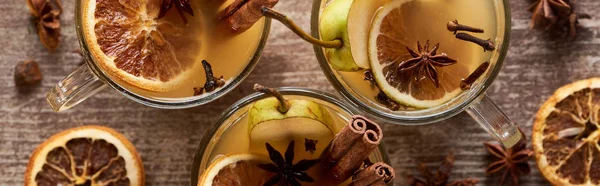 Top view of traditional pear mulled wine in glasses with spices on wooden rustic table, panoramic shot — Stock Photo