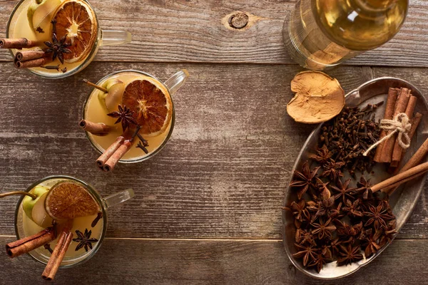 Vue de dessus du vin chaud traditionnel poire avec des épices sur table rustique en bois — Photo de stock