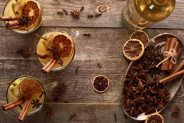 Draufsicht auf traditionellen Birnenglühwein mit Gewürzen auf rustikalem Holztisch — Stockfoto