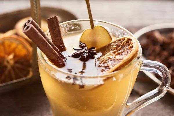 Close up view of seasonal traditional pear mulled wine with spices and dried citrus in glass — Stock Photo