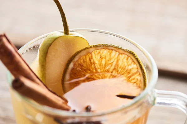 Close up view of seasonal traditional pear mulled wine with cinnamon and dried citrus in glass — Stock Photo