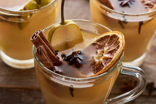 Poire traditionnelle saisonnière vin chaud avec des épices dans des verres sur table rustique en bois — Photo de stock