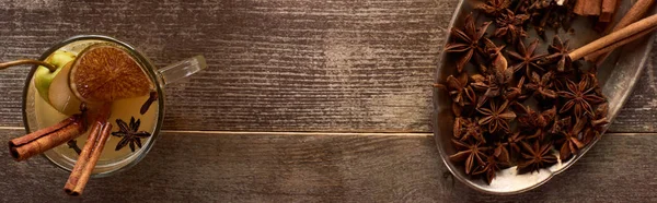 Vista superior del tradicional vino caliente con especias y cítricos secos en la mesa rústica de madera, plano panorámico - foto de stock