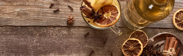 Top view of traditional warm pear mulled wine with spices and dried citrus on wooden rustic table, panoramic shot — Stock Photo