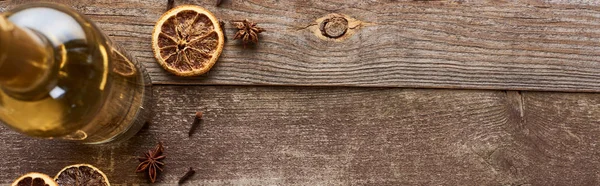 Vin blanc en bouteille près de l'anis et agrumes séchés sur table en bois, vue panoramique — Photo de stock