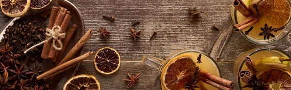 Top view of warm pear mulled wine with spices and dried citrus on wooden rustic table, panoramic shot — Stock Photo