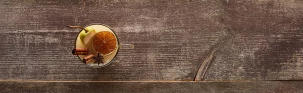 Vista dall'alto del caldo vin brulè alla pera con spezie e agrumi secchi sul tavolo di legno, colpo panoramico — Foto stock