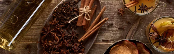 Top view of warm pear mulled wine with spices and dried citrus on wooden table, panoramic shot — Stock Photo