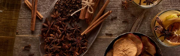 Birnen-Glühwein mit Gewürzen und getrockneten Zitrusfrüchten auf Holztisch, Panoramaaufnahme — Stockfoto