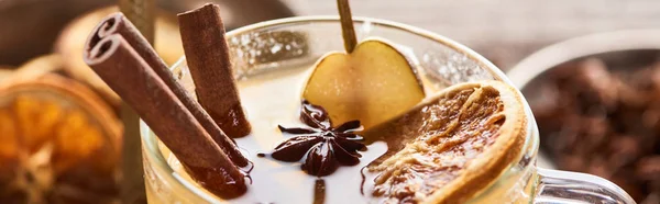 Close up view of delicious pear mulled wine with spices and dried citrus i glass, panoramic shot — Stock Photo