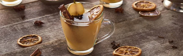 Pear mulled wine with spices and dried citrus on wooden table, panoramic shot — Stock Photo