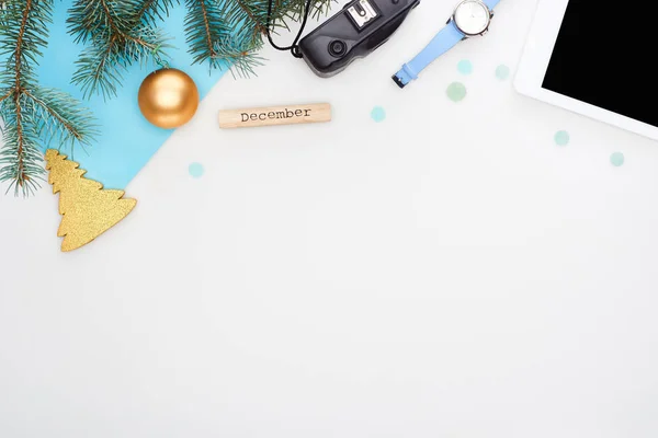 Цифрова камера, ялинкова гілка, різдвяні ваучери, цифровий планшет, дерев'яний блок з вересневим написом, синій папір ізольований на білому — стокове фото