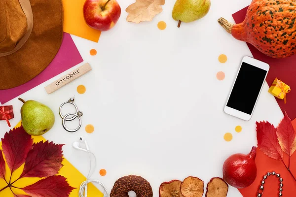 Chapeau, smartphone, fruits, citrouille, feuilles sèches, papiers multicolores, beignet, grains de café, bloc de bois avec inscription octobre isolé sur blanc — Photo de stock