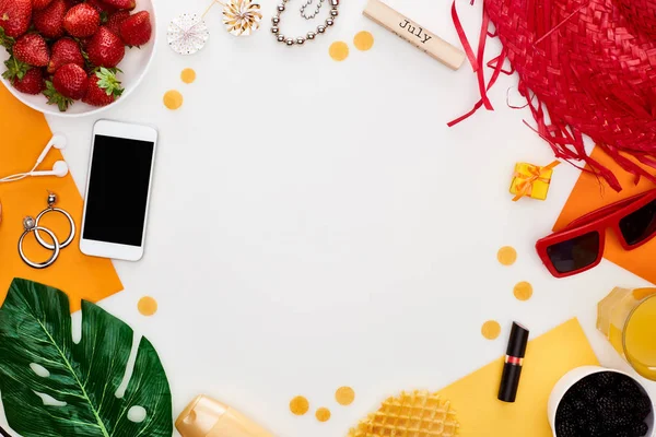 Bloc de bois avec inscription juillet, fraise fraîche, smartphone, chapeau de paille, lunettes de soleil, cosmétiques, feuille verte, gaufres, sucettes isolées sur blanc — Photo de stock