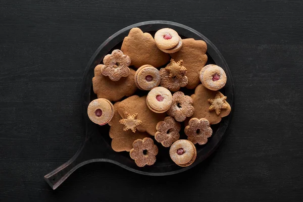 Vista superior de biscoitos de Natal na panela na mesa de madeira preta — Fotografia de Stock