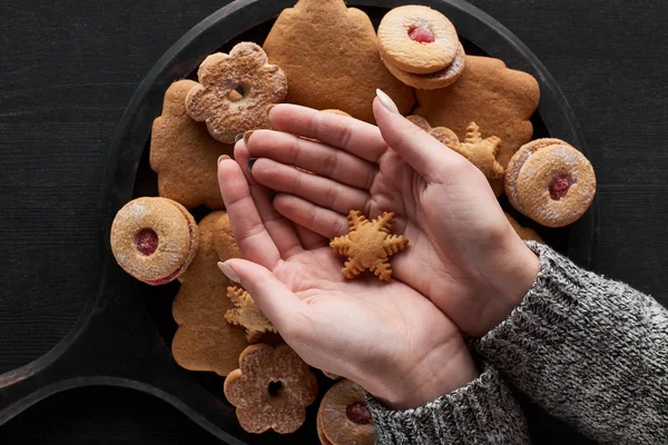 Cropped view of woman holding snowflake cookie in hands — Stock Photo