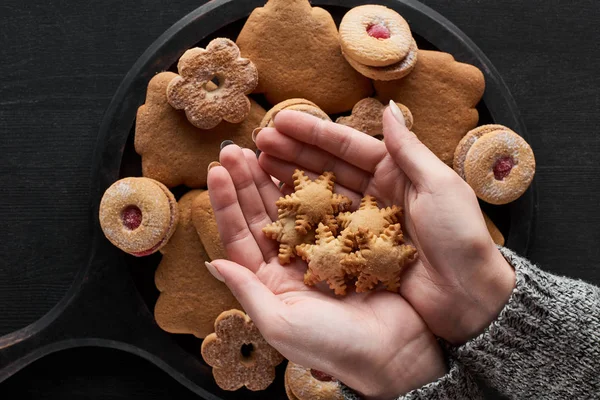 Partial view of woman holding snowflake cookies in hands — Stock Photo