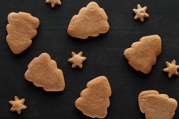 Vista dall'alto di fiocchi di neve e biscotti dell'albero di Natale su tavolo di legno nero — Foto stock