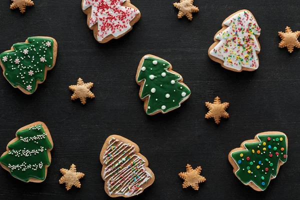 Délicieux biscuits de Noël glacés sur fond noir — Photo de stock