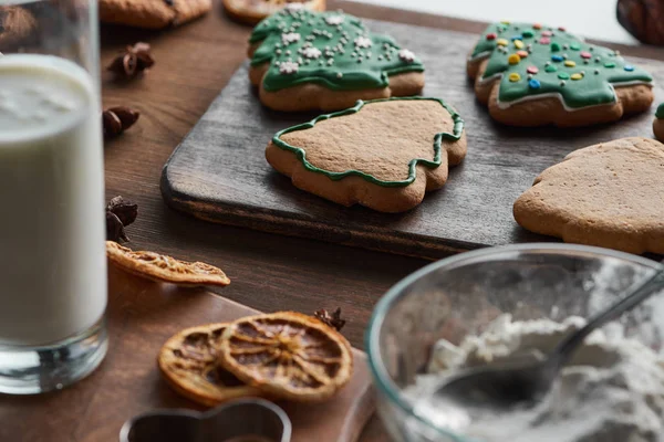 Fuoco selettivo di biscotti di Natale al forno vicino a ingredienti su tavolo di legno — Foto stock