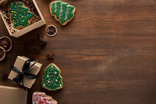 Вид зверху на ялинкове печиво в подарунковій коробці на дерев'яному столі з сушеними цитрусами та анісом — стокове фото