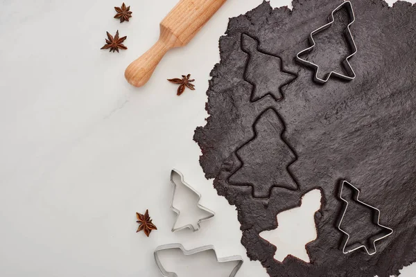 Vista superior de la masa cruda para galletas de Navidad de chocolate sobre fondo blanco cerca de anís y rodillo - foto de stock