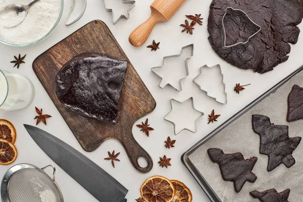 Vue du dessus de la pâte crue pour les biscuits de Noël au chocolat près des ingrédients sur fond blanc — Photo de stock