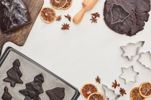 Vue du dessus de la pâte crue pour les biscuits de Noël au chocolat près des ingrédients sur fond blanc — Photo de stock