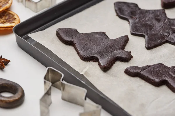 Raw Christmas tree cookies on oven tray with baking paper on white background — Stock Photo