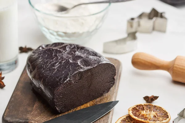 Сырое тесто для шоколадного печенья на деревянной доске с сушеными цитрусовыми на белом фоне — стоковое фото