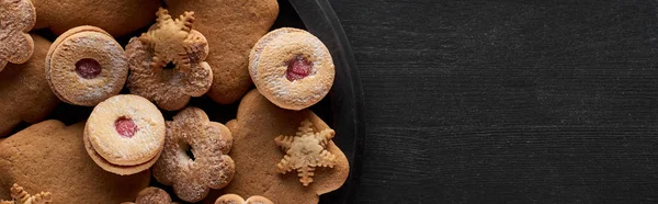 Top view of Christmas cookies in pan on wooden black table, panoramic shot — Stock Photo