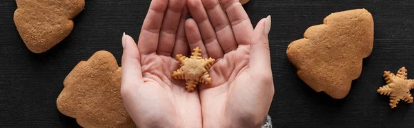 Cropped view of woman holding snowflake cookie in hands, panoramic shot — Stock Photo