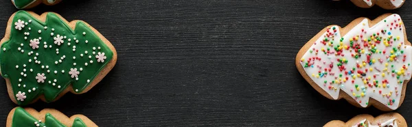 Flache Lage mit leckeren glasierten Christbaumkeksen auf schwarzem Hintergrund mit Kopierraum, Panoramaaufnahme — Stockfoto