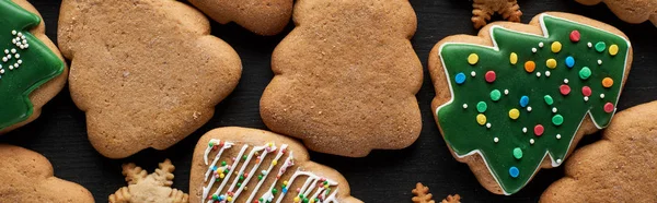 Gustosi biscotti natalizi smaltati su sfondo nero, colpo panoramico — Foto stock