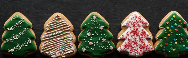 Posa piatta con deliziosi biscotti dell'albero di Natale smaltati sul tavolo di legno nero, colpo panoramico — Foto stock