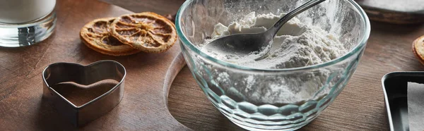 Heart shaped dough mold, flour with spoon in glass bowl, dried citrus slices on wooden table, panoramic shot — Stock Photo