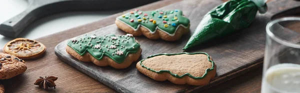 Foco seletivo de biscoitos de Natal assados perto de saco de pastelaria na mesa de madeira, tiro panorâmico — Fotografia de Stock