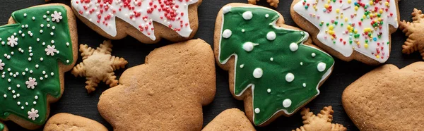 Deliziosi biscotti natalizi smaltati su sfondo nero, colpo panoramico — Foto stock
