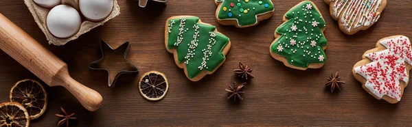 Vista superior de biscoitos de árvore de Natal, moldes de massa, ovos e rolo de pino na mesa de madeira, tiro panorâmico — Fotografia de Stock