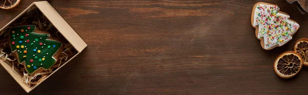 Vue du dessus des biscuits de sapin de Noël, boîte cadeau sur table en bois, vue panoramique — Photo de stock