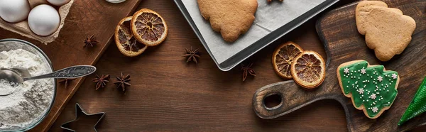 Vista dall'alto di biscotti di Natale e ingredienti su tavolo di legno, colpo panoramico — Foto stock