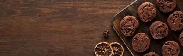 Top view of chocolate cookies on wooden table, panoramic shot — Stock Photo