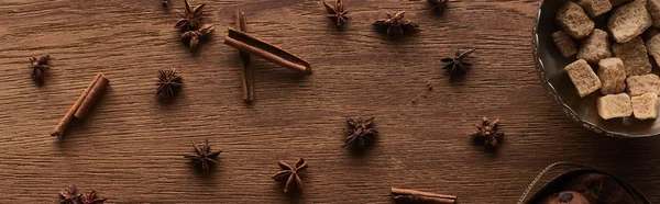 Top view of brown sugar, anise and cinnamon on wooden table, panoramic shot — Stock Photo