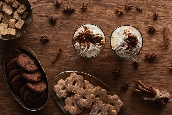 Vue du dessus du cacao de Noël près des biscuits, de l'anis, de la cannelle et de la cassonade sur table en bois — Photo de stock