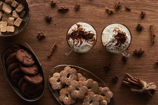 Vista superior del cacao de Navidad cerca de galletas, anís, canela y azúcar morena en la mesa de madera - foto de stock